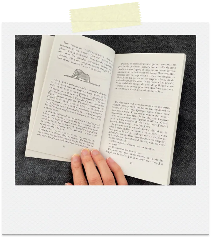 The Little Prince book open to the drawing of a boa constrictor that looks like a hat