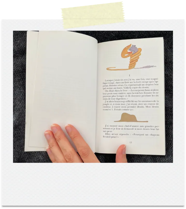 The Little Prince book open to the drawing of an elephant swallowed by a boa constrictor