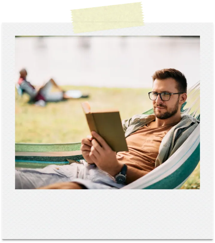 A man reading in a hammock outdoors